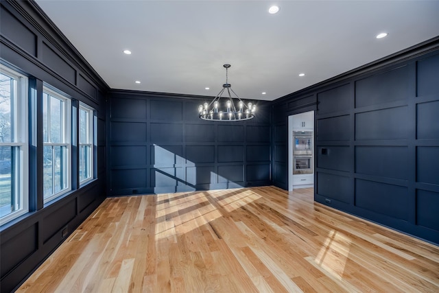 interior space featuring a notable chandelier, crown molding, and light hardwood / wood-style floors