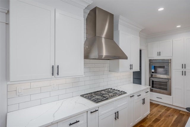 kitchen featuring tasteful backsplash, extractor fan, white cabinetry, stainless steel appliances, and light stone counters