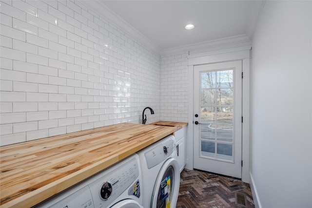 clothes washing area with sink, separate washer and dryer, and ornamental molding