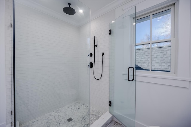 bathroom with a shower with door and crown molding