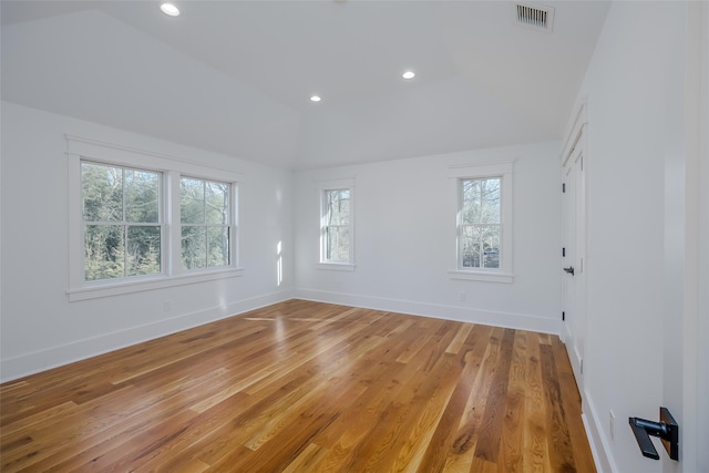 spare room with vaulted ceiling and light hardwood / wood-style floors