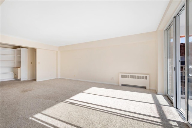 unfurnished room with light colored carpet and radiator heating unit