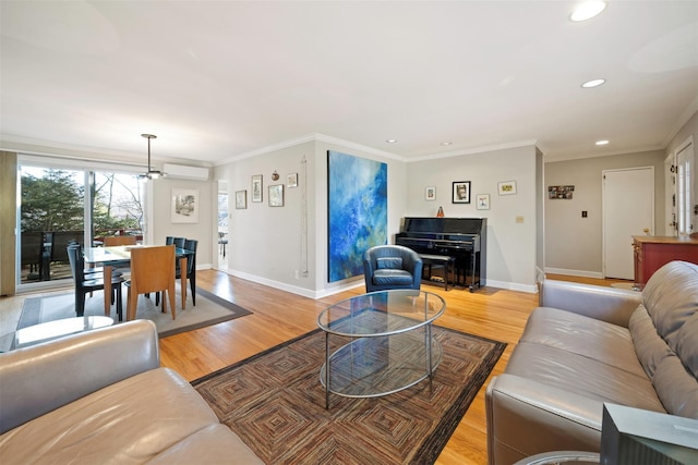 living room featuring a wall mounted AC, ornamental molding, and light hardwood / wood-style flooring