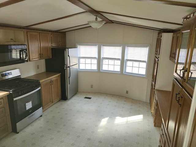 kitchen with stainless steel appliances and vaulted ceiling with beams