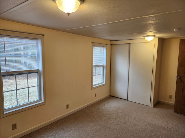 unfurnished bedroom with a textured ceiling, a closet, and carpet floors