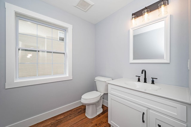 bathroom featuring toilet, vanity, and hardwood / wood-style floors