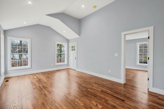 unfurnished living room featuring vaulted ceiling and wood-type flooring