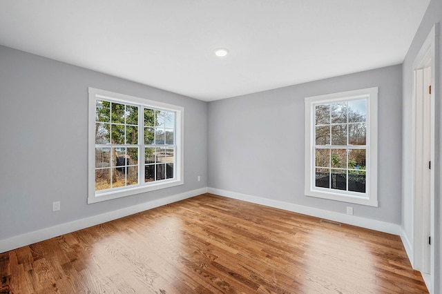 unfurnished room featuring a healthy amount of sunlight and hardwood / wood-style floors