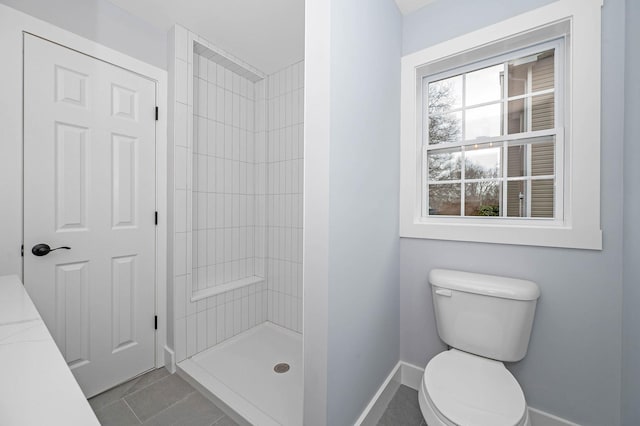 bathroom featuring toilet, a healthy amount of sunlight, a shower, and tile patterned floors