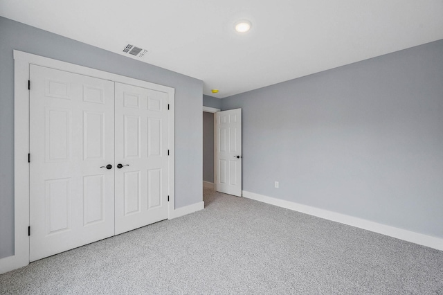 unfurnished bedroom featuring light carpet and a closet