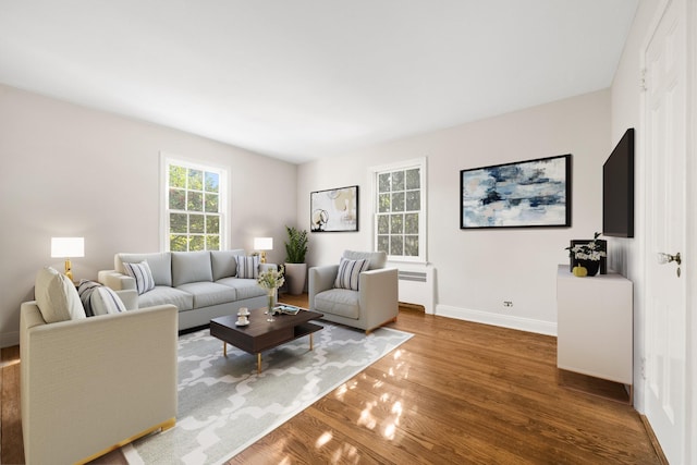 living room featuring dark wood-type flooring and radiator heating unit