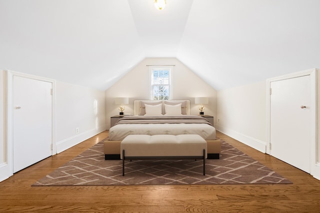 bedroom featuring dark wood-type flooring and vaulted ceiling