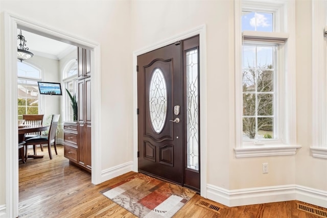 entryway featuring light hardwood / wood-style floors and crown molding