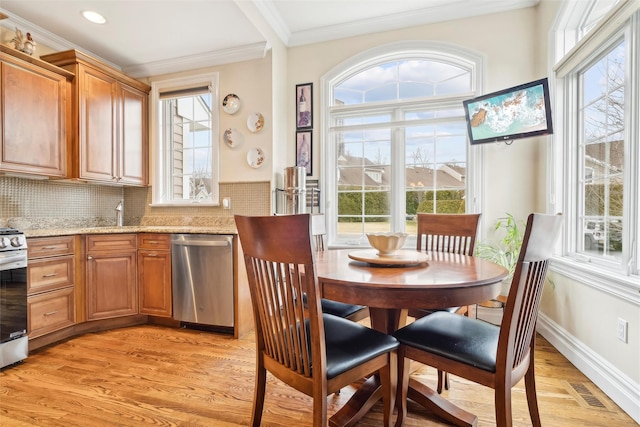 dining room featuring ornamental molding and light wood-type flooring