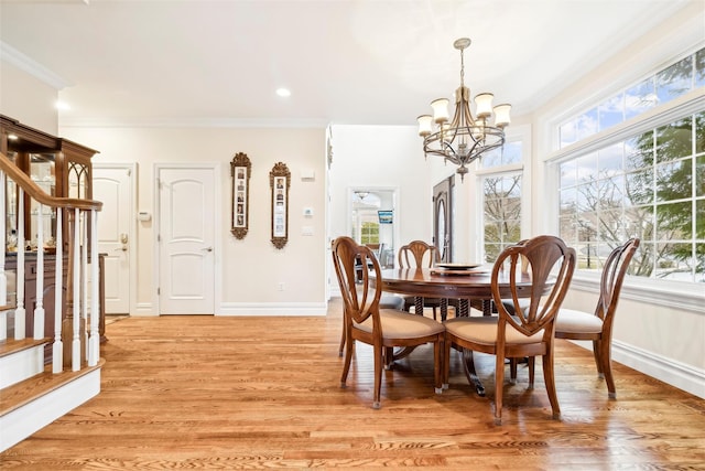 dining space featuring a notable chandelier, crown molding, a wealth of natural light, and light hardwood / wood-style flooring