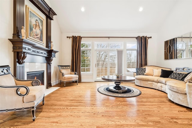 living room with light wood-type flooring and vaulted ceiling