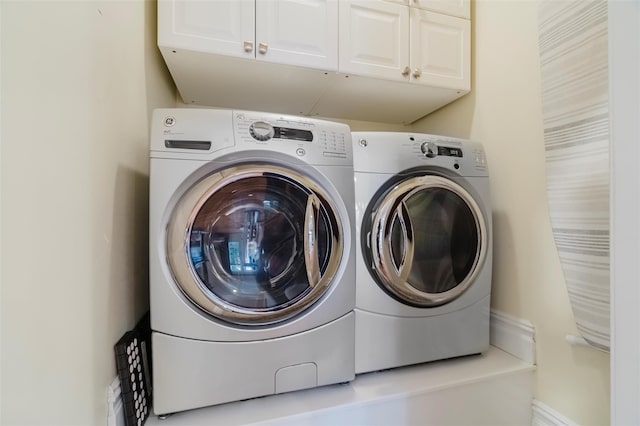 laundry room with washer and clothes dryer and cabinets