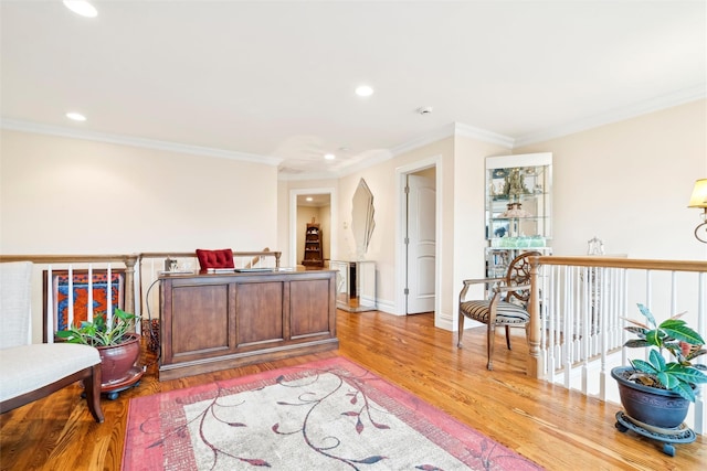 sitting room with light hardwood / wood-style flooring and crown molding