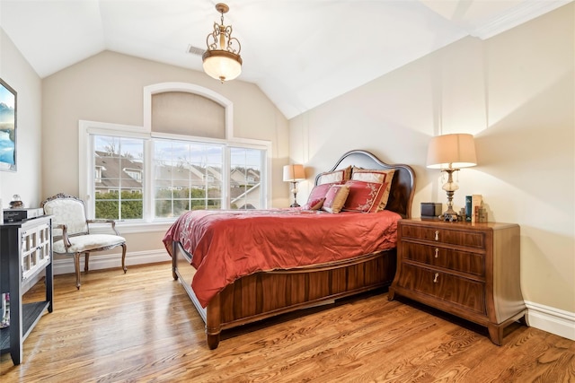 bedroom with light wood-type flooring and vaulted ceiling