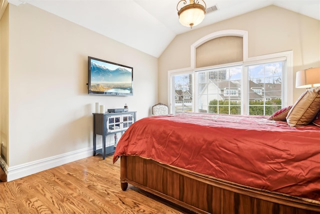 bedroom with light hardwood / wood-style flooring and lofted ceiling