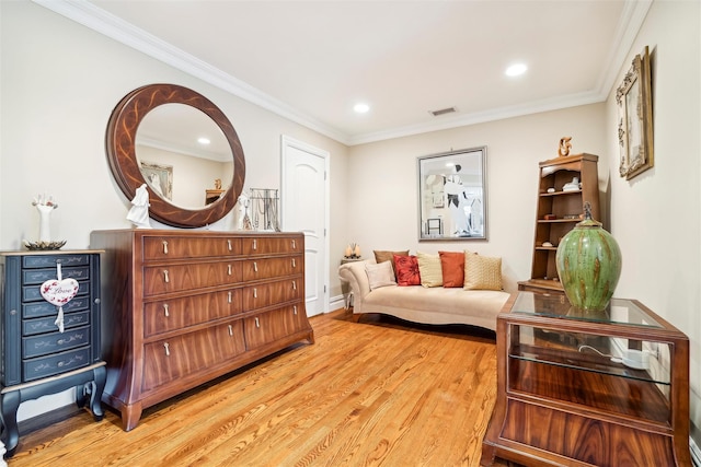 living area featuring light wood-type flooring and crown molding