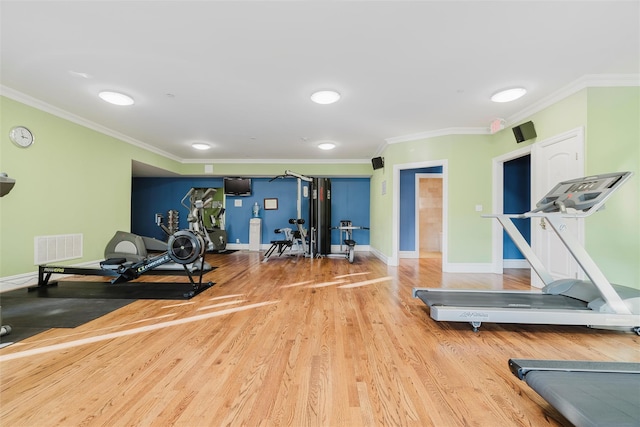 workout room with ornamental molding and hardwood / wood-style flooring