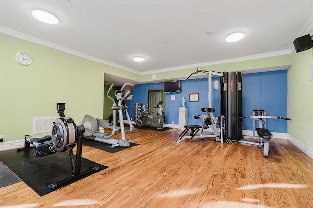 workout room with hardwood / wood-style floors and crown molding