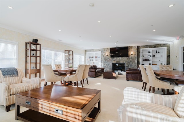 living room featuring light colored carpet, a stone fireplace, and crown molding