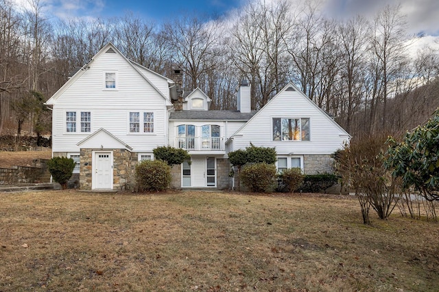 front of property with a balcony and a front lawn