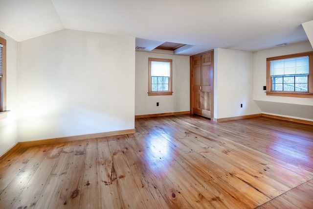 additional living space featuring lofted ceiling and light hardwood / wood-style floors