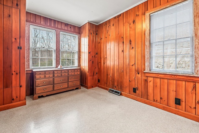 bedroom featuring wooden walls and ornamental molding