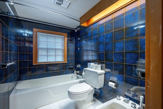 bathroom with shower / washtub combination, tile walls, tile patterned floors, and toilet