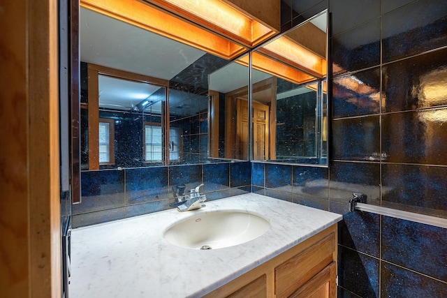 bathroom with vanity, tile walls, and backsplash