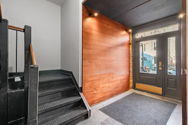 foyer featuring wooden walls