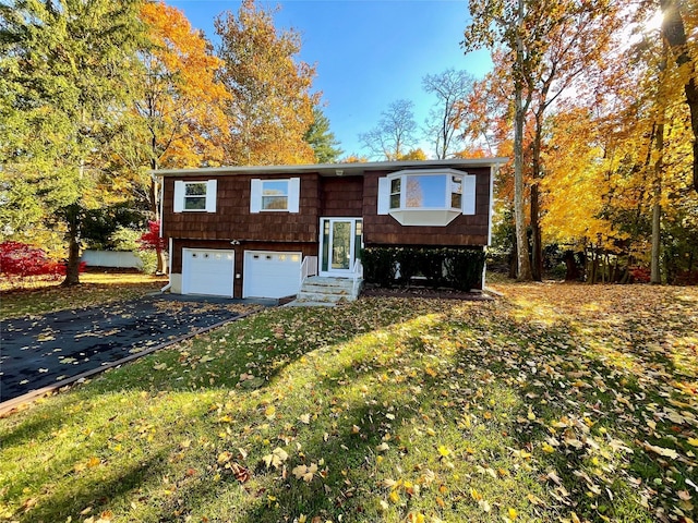 bi-level home featuring a garage and a front lawn