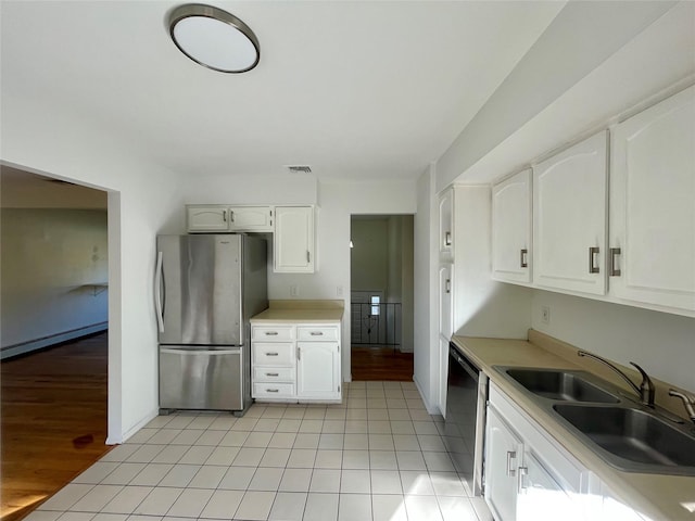 kitchen with sink, white cabinetry, dishwasher, a baseboard heating unit, and stainless steel refrigerator