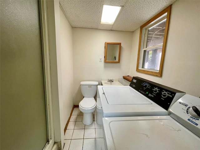 interior space featuring washing machine and dryer, light tile patterned flooring, and sink