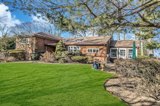 rear view of property featuring a lawn