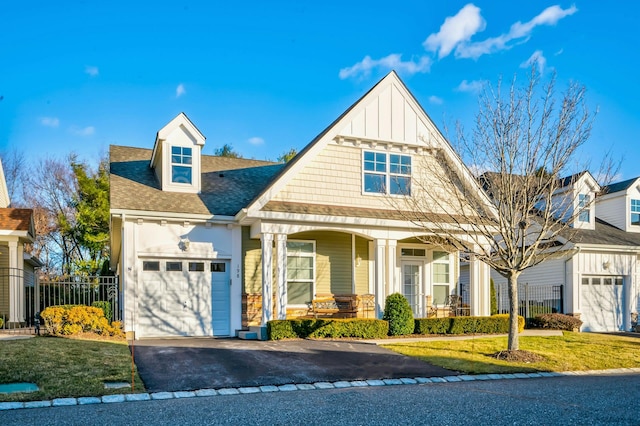 view of front of property with a front yard, covered porch, and a garage