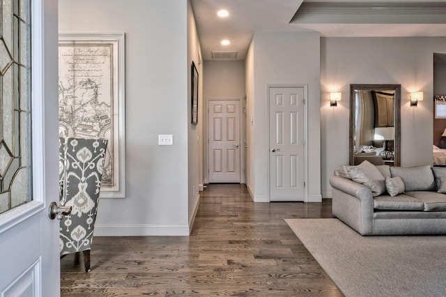 foyer featuring ornamental molding and dark hardwood / wood-style flooring