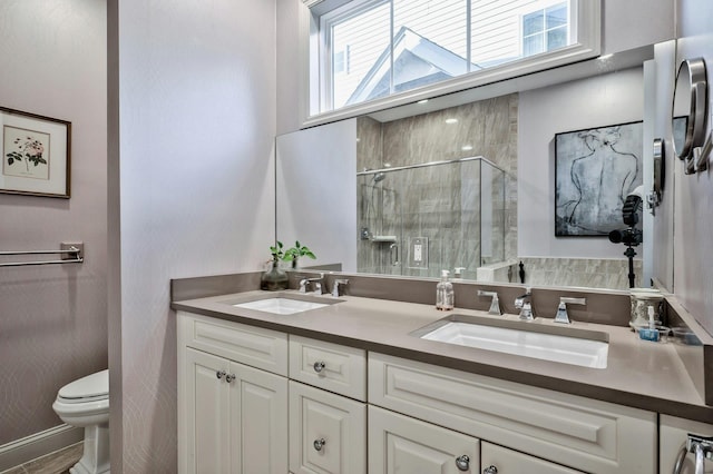 bathroom featuring an enclosed shower, vanity, and toilet