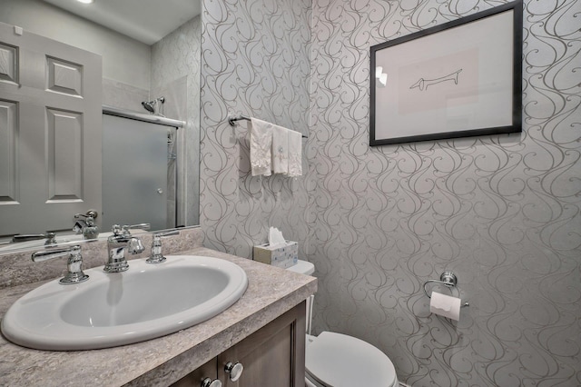 bathroom featuring vanity, a shower with shower door, and toilet