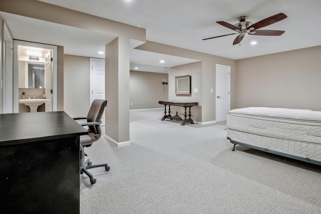 bedroom featuring sink, ensuite bath, ceiling fan, and light colored carpet