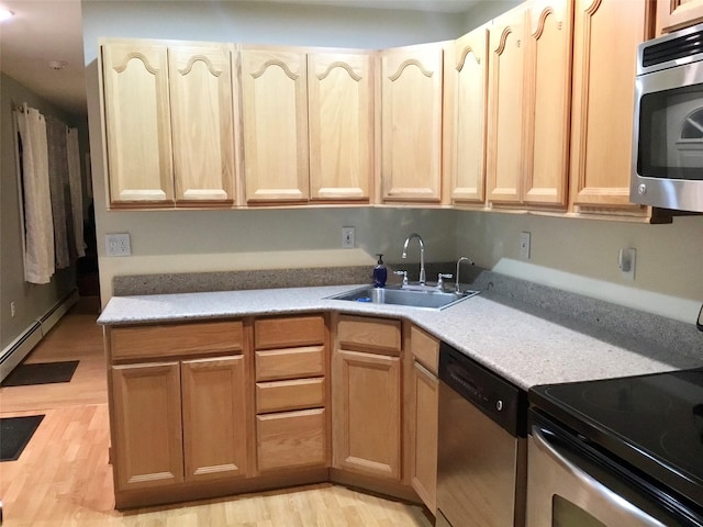 kitchen featuring sink, stainless steel appliances, light wood-type flooring, and light brown cabinetry