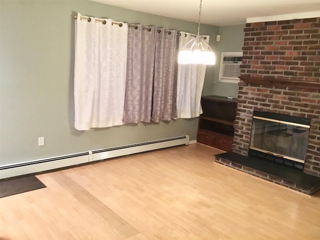 interior space with hardwood / wood-style floors, an AC wall unit, a brick fireplace, and a baseboard heating unit