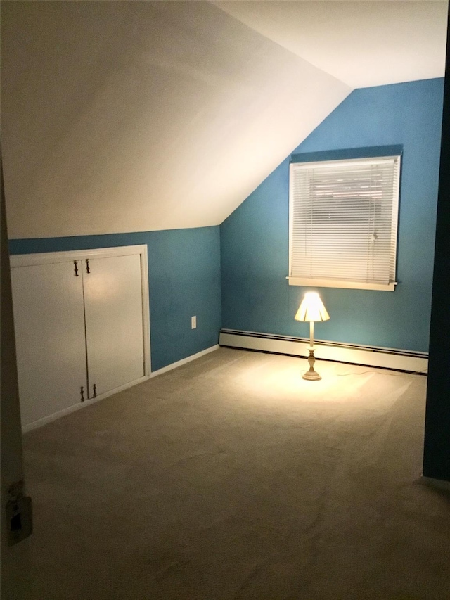 additional living space with a baseboard radiator, lofted ceiling, and carpet floors