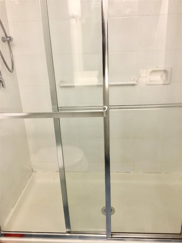 bathroom with a shower with door