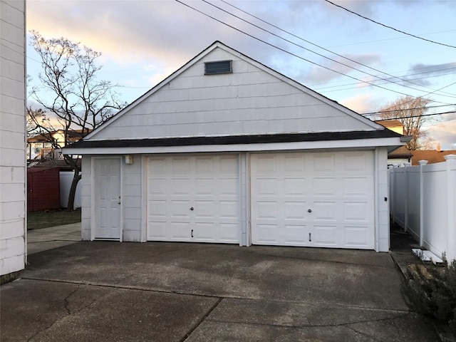 view of garage at dusk