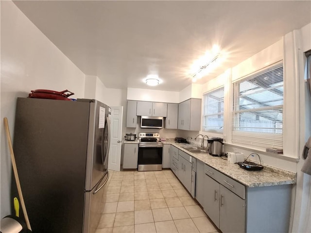 kitchen with sink, light tile patterned floors, gray cabinets, and stainless steel appliances