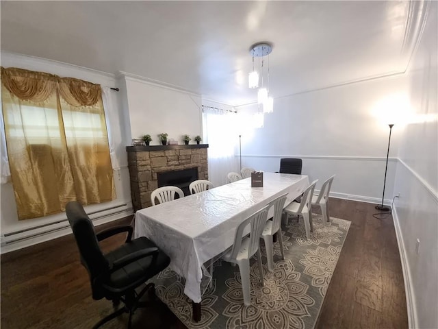 dining room with a fireplace, dark wood-type flooring, and ornamental molding